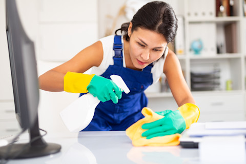 A cleaning lady is holding her supplies